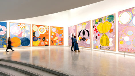 Visitors in the Guggenheim museum standing in front of colorful paintings by Hilma af Klint