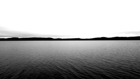 Marcella Ernest, video still depicting Gunflint Lake, a large dark body of water with a gray sky above
