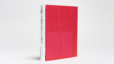 A book with a fuchsia cover that says "gego" in faint pink lettering, against a white backdrop.