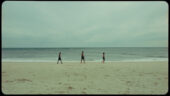 A video still of artist Rashid John with his father, Rashid Johnson, and his son, walking in a line along the beach.
